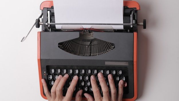 Hands writing on typewriter