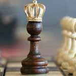 Kings crown placed onto a pawn in the center of a chess board