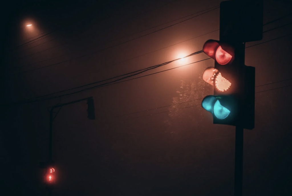 A traffic light on a foggy night