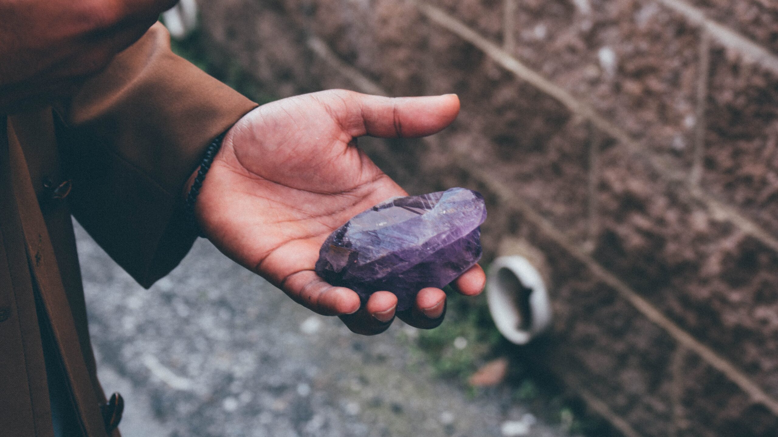 Person holding an amethyst stone