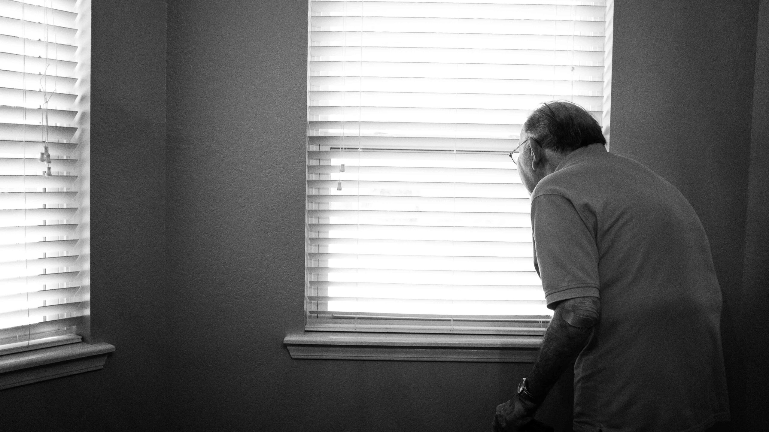 Elderly man looking out a window
