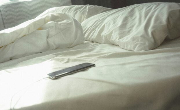 Cell phone on an unmade bed