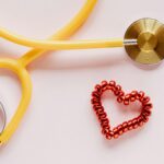 Yellow stethoscope with a red heart-shaped coil next to it