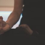 Person sitting on the floor meditating