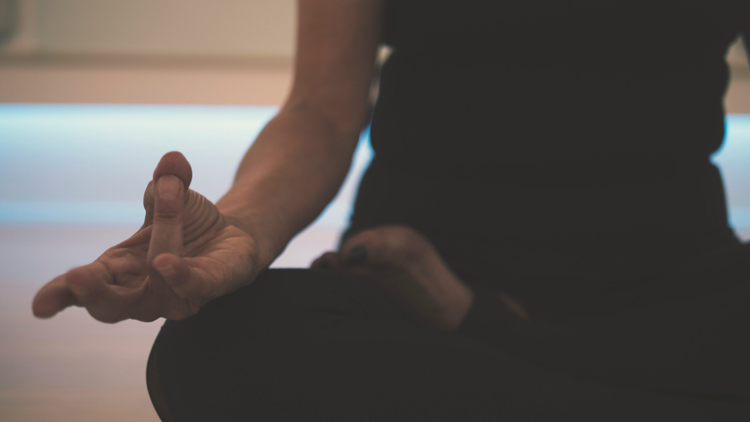 Person sitting on the floor meditating