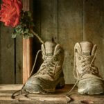 A pair of work boots with a rose inside one of them