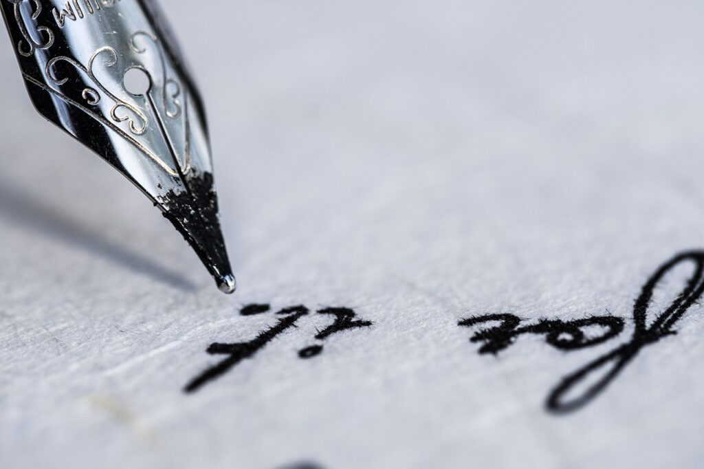 Old-fashioned ink pen poised above a parchment paper on which the words "for it" are visible.