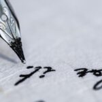 Old-fashioned ink pen poised above a parchment paper on which the words "for it" are visible.