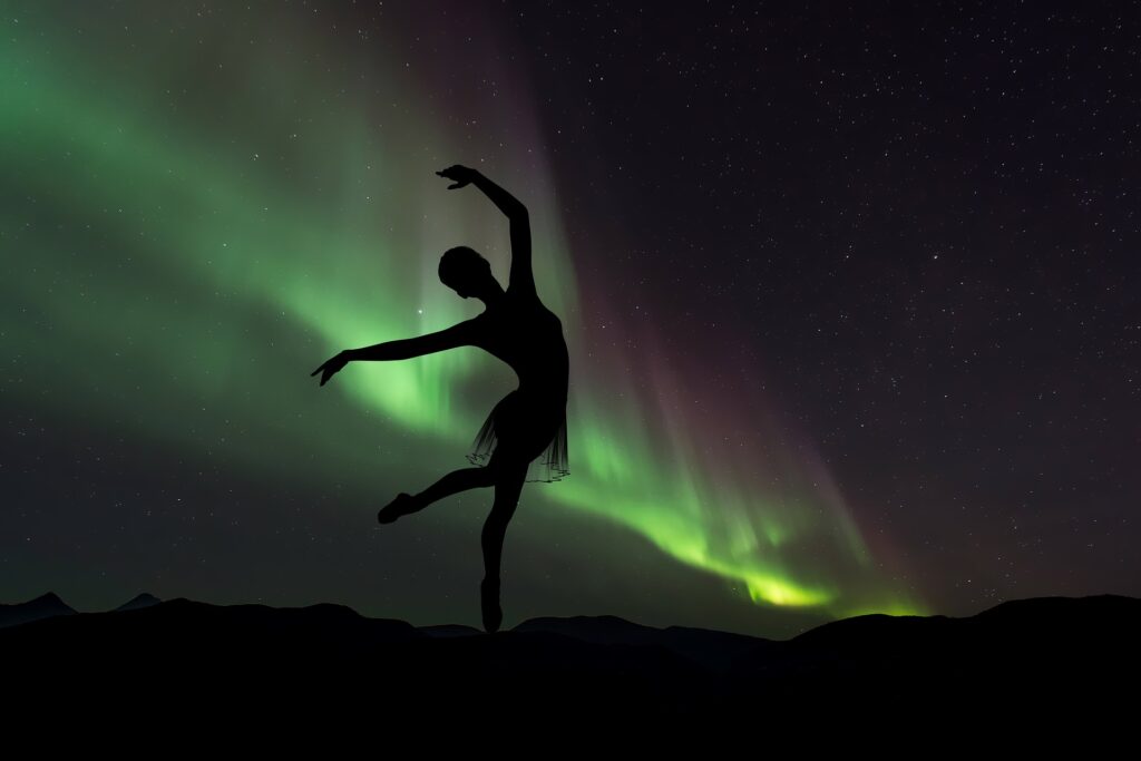 Ballerina dancing in front of the Northern Lights.