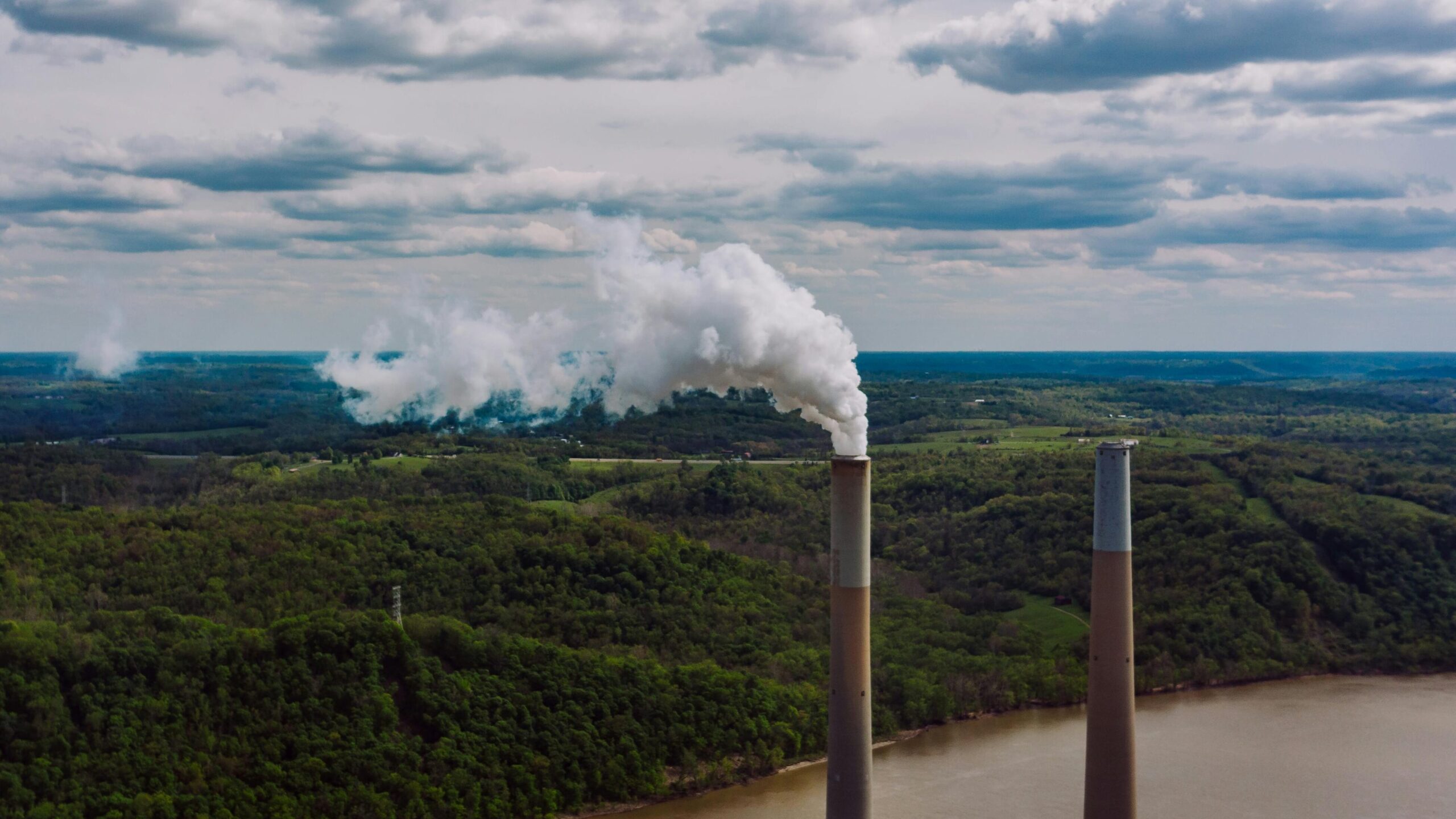 A polluted river with smokestacks in the foreground. 