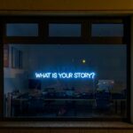 A neon sign that says, "What is Your Story?"
